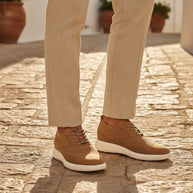 Man wearing the Looksmaxxing Capri elevator trainers on a Mediterranean street