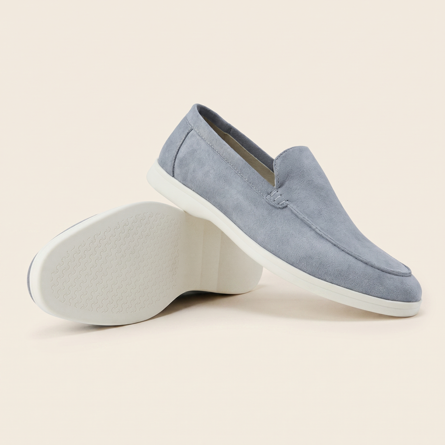 Pair of grey-blue Italian Cut suede loafers, one turned to show the white sole