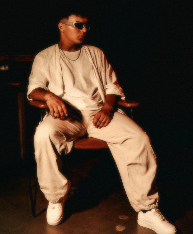 Man in cream outfit seated